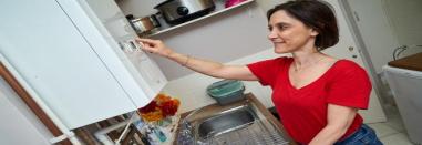 Woman adjusting the boiler in her home